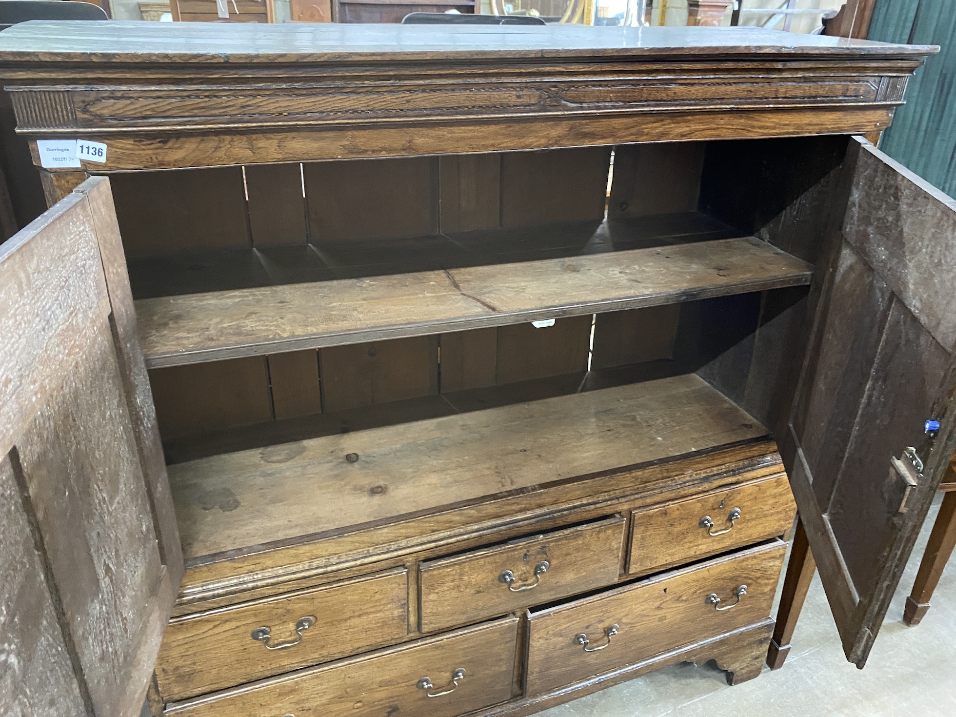 A late 18th century oak two door press cupboard, the base fitted with five small drawers, width 140cm, depth 50cm, height 152cm